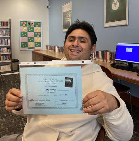 Learner receiving certificate of completion for major milestone in reading studies